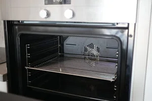 Clean oven interior with metal racks and heating elements visible